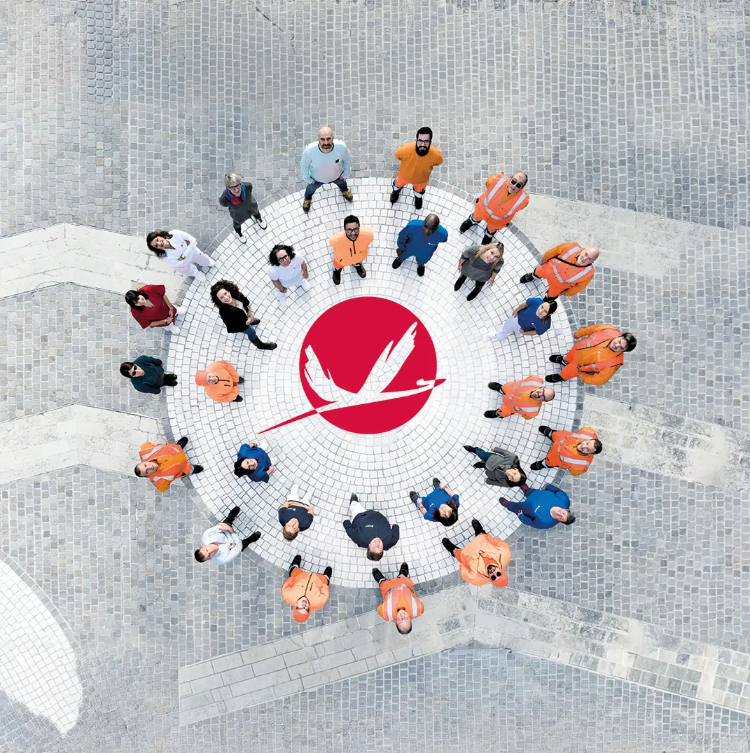 Dipendenti Idealservice intorno al logo